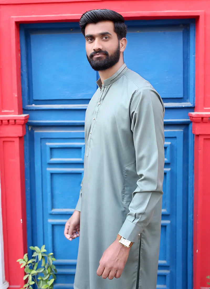 Full-length shot of a model wearing green muted kurta shalwar for men, styled for traditional occasions and daily wear.